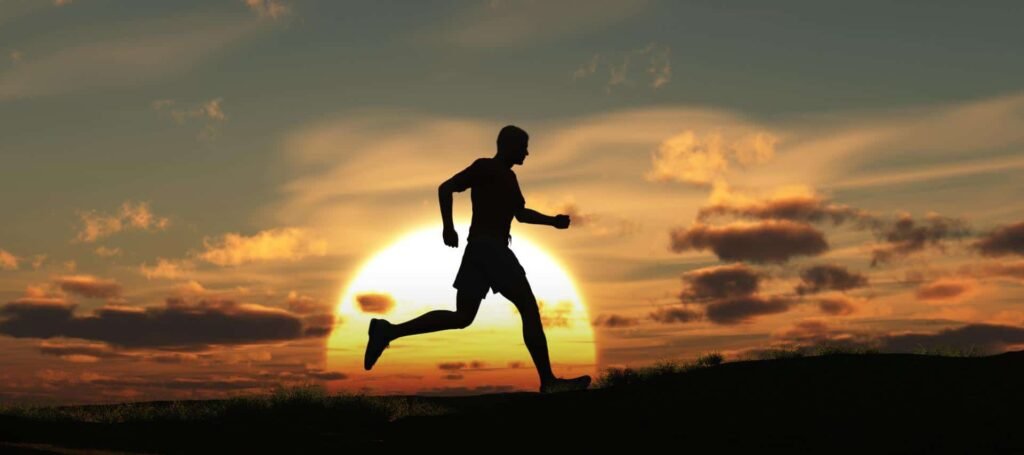 sombra de hombre corriendo al subir una cuesta en un amanecer o puesta de sol