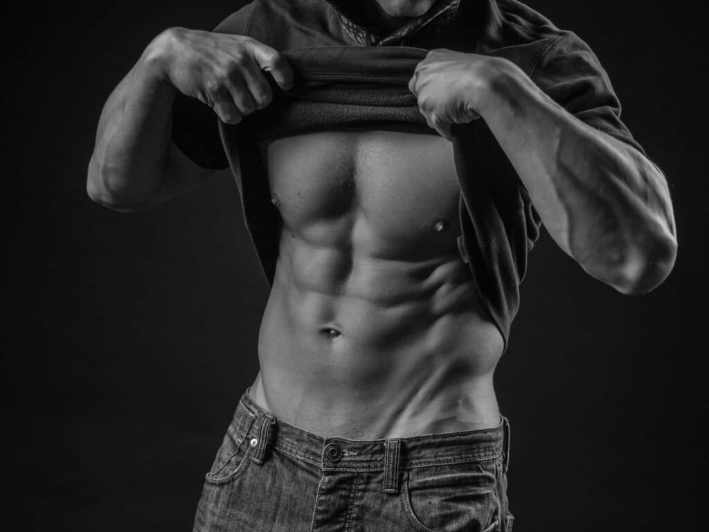 hombre con abdominales definidos levantando su camiseta