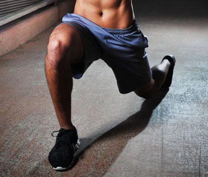 cliente haciendo una zancada con su pierna derecha durante un entrenamiento personalizado