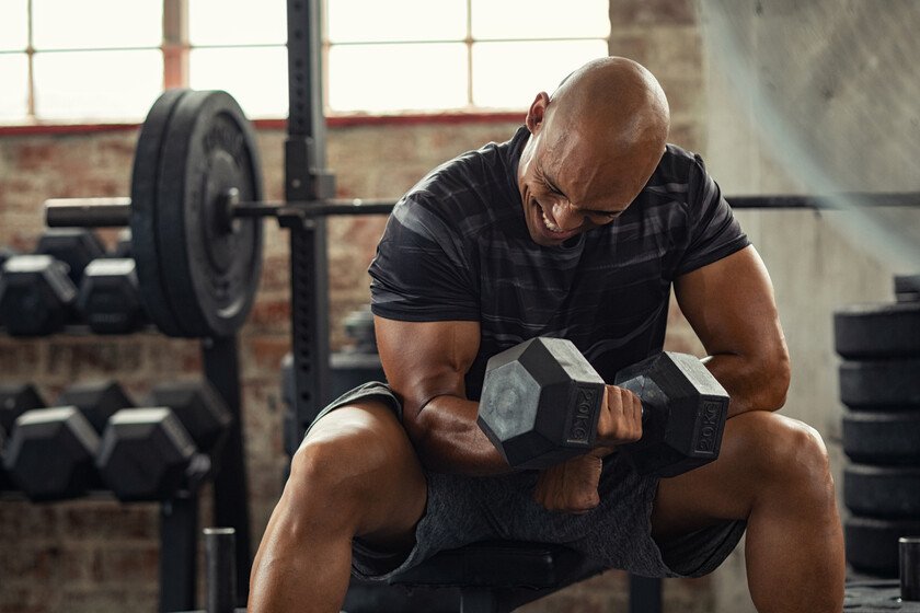usuario de gimnasio levantando una mancuerna con su brazo derecho
