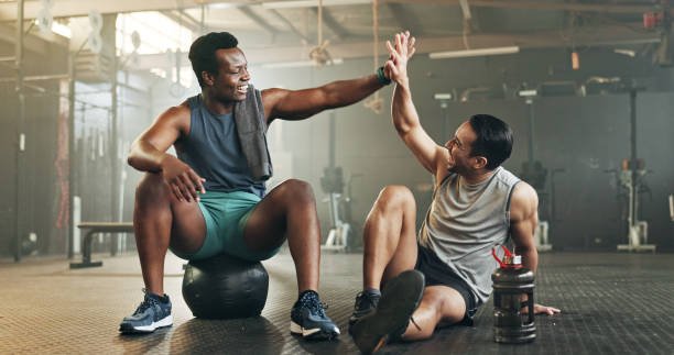 dos amigos chocan su mano derecha después de un entrenamiento funcional en el gimnasio