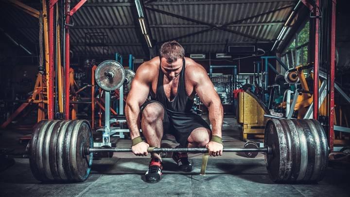 powerlifter en el gimnasio preparado para levantar una barra con gran cantidad de discos
