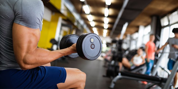 cliente de gimnasio levantando una mancuerna con su mano derecha