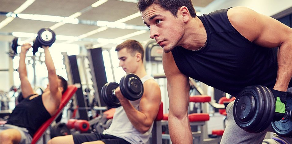 3 clientes de gimnasio entrenando a la vez