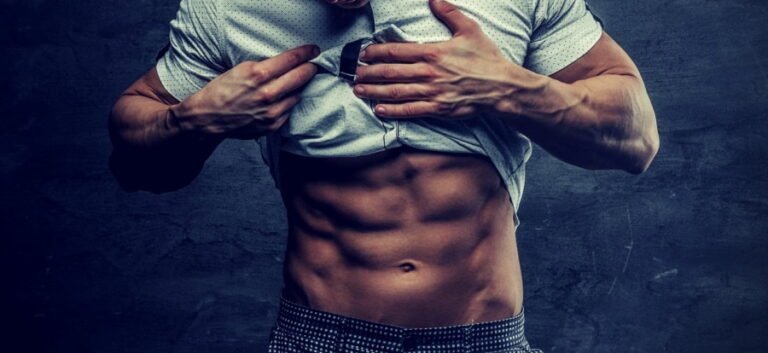 hombre bronceado levanta su camiseta de color blanco para dejar ver sus abdominales